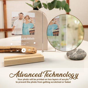 May include: A clear acrylic photo frame with a wooden base. The frame features a photo of a couple and a music player interface with the song title "This I Promise You" by NSYNC. The text "Advanced Technology" is written below the frame. The text explains that the photo is printed on two layers of acrylic to prevent scratching or fading.