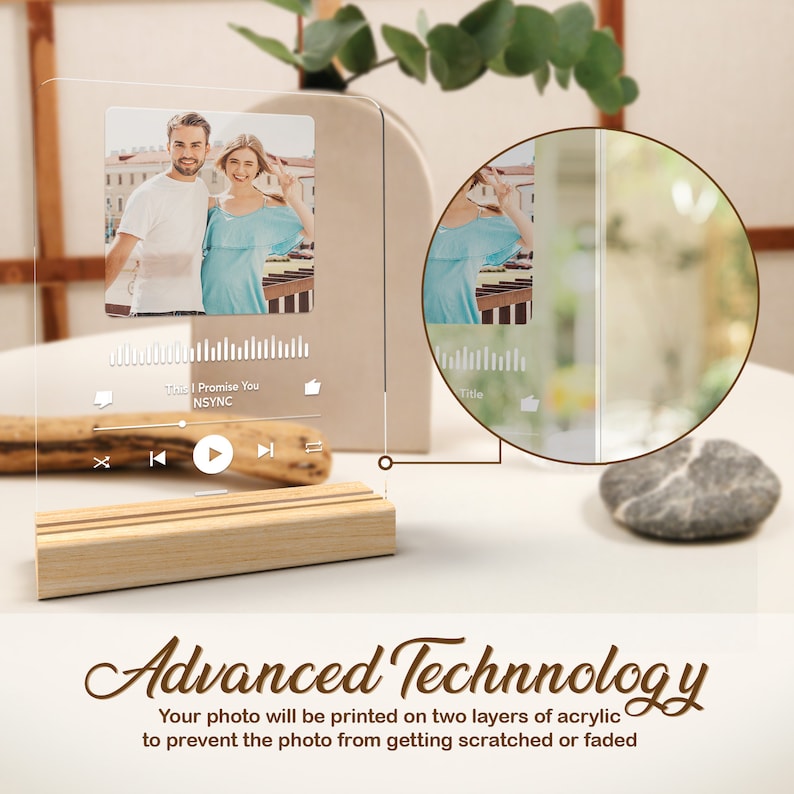 May include: A clear acrylic photo frame with a wooden base. The frame features a photo of a couple and a music player interface with the song title "This I Promise You" by NSYNC. The text "Advanced Technology" is written below the frame. The text explains that the photo is printed on two layers of acrylic to prevent scratching or fading.