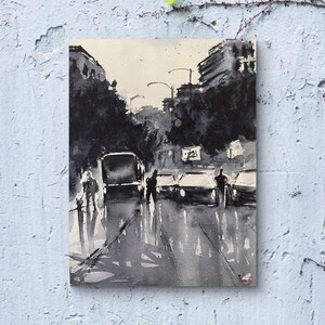 May include: Black and white watercolor painting of a city street scene. The artwork depicts cars, buildings, and figures in a rainy environment. The painting has a minimalist style with a focus on light and shadow.