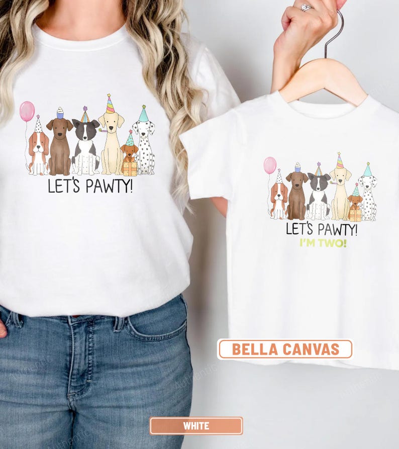 May include: White t-shirts with a dog-themed birthday party design. The adult shirt says "Let's Pawty!" and the child's shirt says "Let's Pawty! I'm Two!" The shirts feature illustrations of dogs wearing party hats and holding a pink balloon.