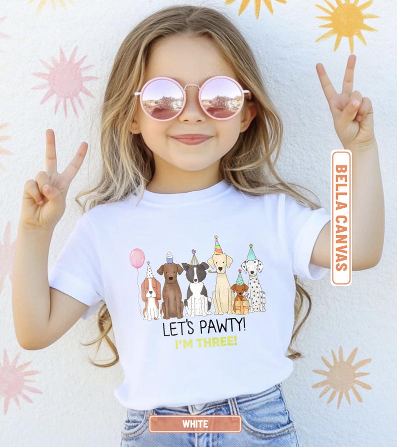 May include: White Bella Canvas t-shirt featuring a colorful illustration of six cartoon dogs wearing party hats and holding a balloon. The text "LET'S PAWTY! I'M THREE!" is printed below the dogs.