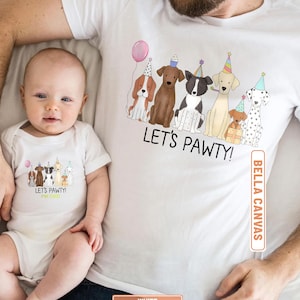 May include: White t-shirts and baby onesie with a "Let's Pawty!" graphic featuring cartoon dogs wearing party hats and holding a balloon. The onesie is worn by a baby, and the t-shirt is worn by an adult.