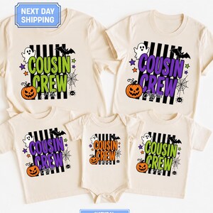 May include: Five natural-colored shirts and a bodysuit featuring a black and white vertical striped background with a Halloween graphic. The design includes a ghost, bat, spider, web, stars, and a pumpkin, with the text COUSIN CREW in various colors.