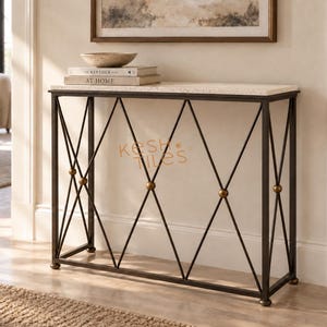 May include: A rectangular console table with a light-colored speckled stone top and a dark metal frame featuring a diamond-shaped lattice pattern with small brass-toned spheres at the intersections. The text KESH TILES is visible on the frame.