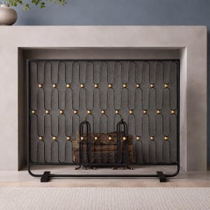May include: A rectangular black metal fireplace screen featuring a repeating vertical wave pattern. The design is accented with small, evenly spaced gold-toned spherical beads at each intersection of the metal frame, supported by two flat feet.