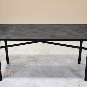 Puede incluir: Mesa rectangular negra con tapa de mosaico y estructura de metal negro. La mesa tiene un diseño moderno y es adecuada para uso en interiores. Las dimensiones de la mesa no son visibles en la imagen.