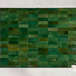 Pode incluir: Uma folha de mosaico de azulejos retangulares de pequeno tamanho, de cor verde. Os azulejos est&atilde;o dispostos em forma de tijolo. A folha &eacute; de pedra natural e tem um aspeto r&uacute;stico.