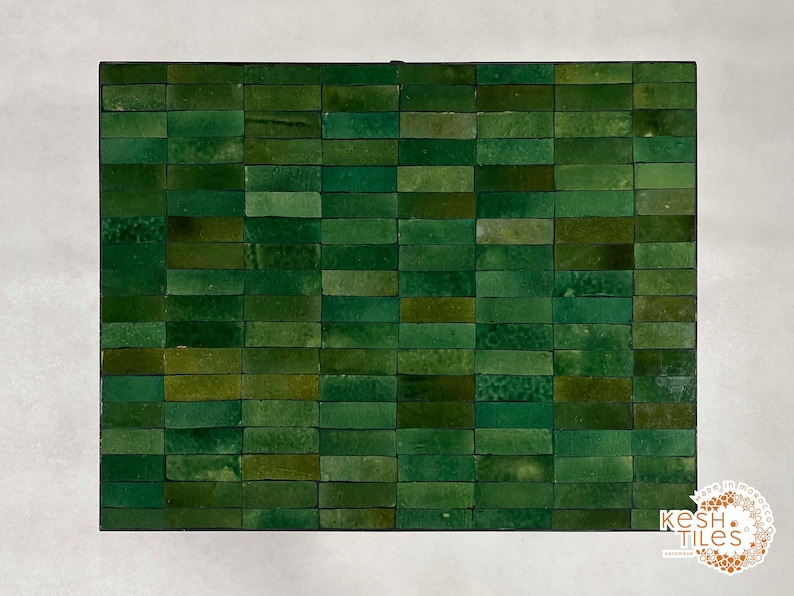 Pode incluir: Uma folha de mosaico de azulejos retangulares de pequeno tamanho, de cor verde. Os azulejos est&atilde;o dispostos em forma de tijolo. A folha &eacute; de pedra natural e tem um aspeto r&uacute;stico.