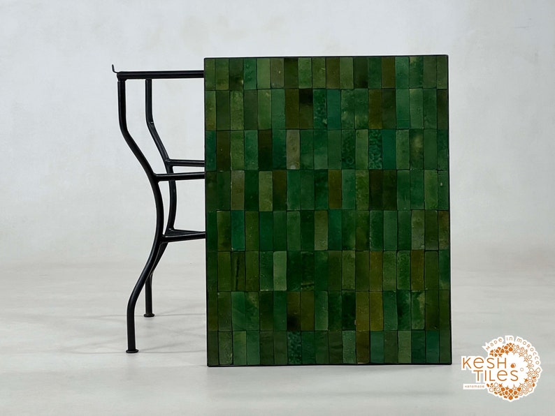 Pode incluir: Uma mesa com tampo de azulejos verdes e estrutura de metal preto. Os azulejos est&atilde;o dispostos em um padr&atilde;o de mosaico. A mesa &eacute; feita pela Kesh Tiles.