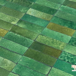 Pode incluir: Azulejos de cer&acirc;mica verde esmaltados dispostos em um padr&atilde;o escalonado. Os azulejos s&atilde;o retangulares e t&ecirc;m uma superf&iacute;cie ligeiramente irregular. Os azulejos s&atilde;o uma mistura de tons de verde claro e escuro.