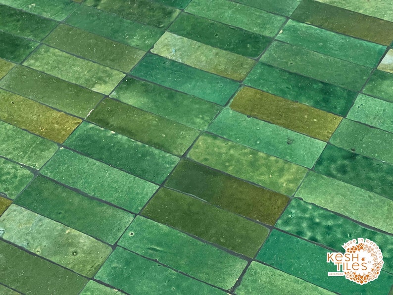 Pode incluir: Azulejos de cer&acirc;mica verde esmaltados dispostos em um padr&atilde;o escalonado. Os azulejos s&atilde;o retangulares e t&ecirc;m uma superf&iacute;cie ligeiramente irregular. Os azulejos s&atilde;o uma mistura de tons de verde claro e escuro.