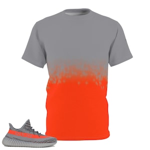 Puede incluir: Una camiseta con degradado gris y naranja con una zapatilla deportiva gris y naranja a juego. La camiseta tiene cuello redondo y mangas cortas. La zapatilla tiene rayas grises y naranjas y el texto "SPLY-350".