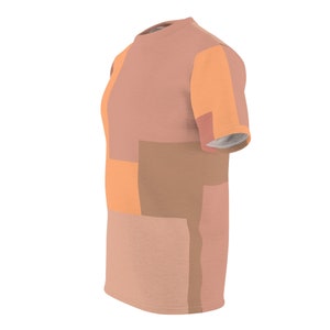 K&ouml;nnte beinhalten: Ein T-Shirt mit kurzen &Auml;rmeln und einem geometrischen Muster in den Farben Pfirsich, Orange und Braun.
