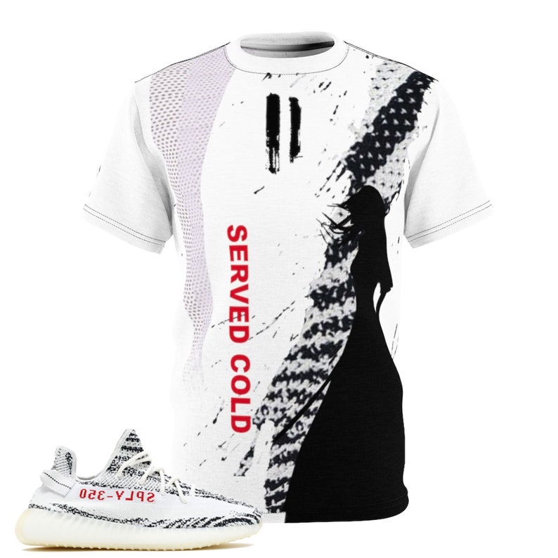 May include: White t-shirt with a black and white graphic design and the text "SERVED COLD" in red. A pair of white and black sneakers with red text are in the foreground. The shirt features a silhouette of a person.