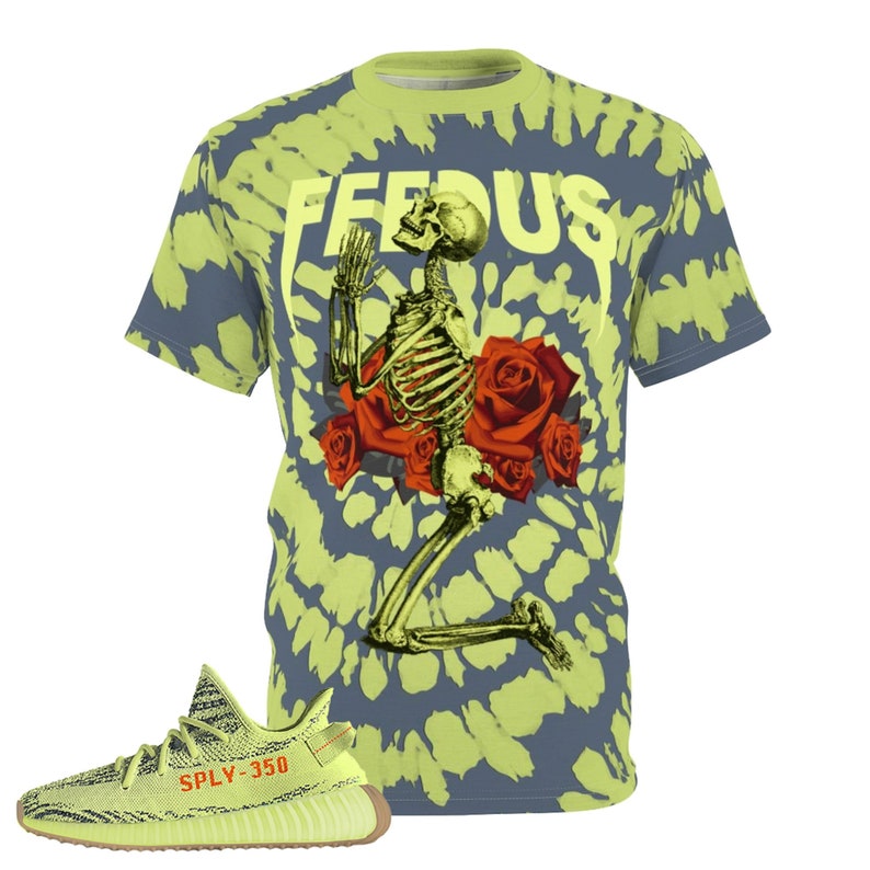 May include: A tie-dye t-shirt with a skeleton graphic kneeling before red roses, with the word "FEEDUS" in yellow. Next to the shirt is a pair of yellow and brown sneakers with the text "SPLY-350".