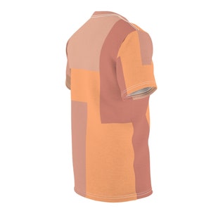 K&ouml;nnte beinhalten: Ein T-Shirt mit kurzen &Auml;rmeln und einem geometrischen Muster in Orange- und Braunt&ouml;nen.