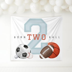May include: White banner with a blue number two, the words "Born Two Ball" and illustrations of a soccer ball, baseball, golf ball, football, and basketball.