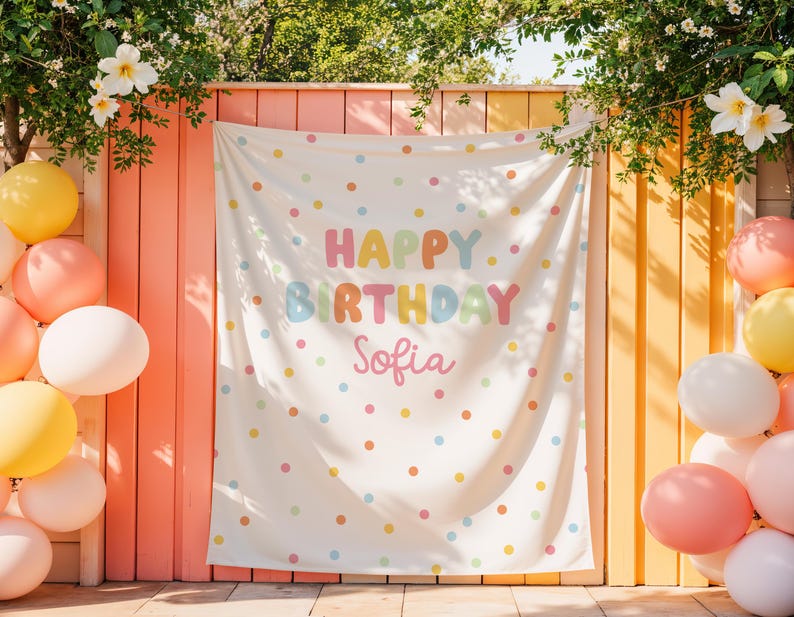 May include: A white birthday banner with colorful polka dots and the words "HAPPY BIRTHDAY Sofia" in pastel colors. Balloons in shades of yellow, pink, and white are on the left and right sides of the banner. Flowers and greenery are at the top.
