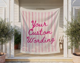 May include: A custom banner with vertical pink stripes and the words "Your Custom Wording" in a cursive font. The banner is hanging in an outdoor setting, with olive trees in pots on either side.