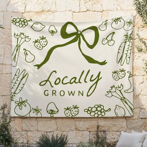 May include: A white banner with green illustrations of fruits, vegetables, and a bow. The banner reads "Locally Grown".