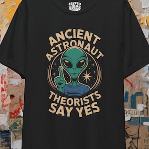Puede incluir: Camiseta negra con un gráfico de un extraterrestre verde y el texto "Ancient Astronaut Theorists Say Yes".