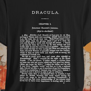 May include: A black t-shirt with a white print of the first chapter of Bram Stoker's Dracula novel. The text includes the title "Dracula", "Chapter I", "Jonathan Harker's Journal", and the first few paragraphs of the book.