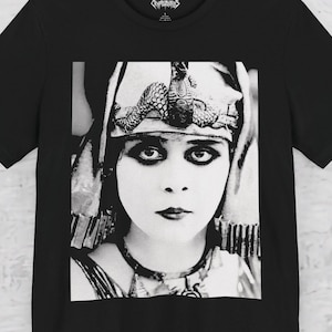 May include: Black t-shirt with a black and white portrait of a woman in a decorative headpiece and jewellery. The image is vintage. The t-shirt has a crew neck and short sleeves.