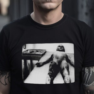 Graphic UFO t-shirt featuring an Area 51 alien autopsy design. Inspired by X-Files and Roswell lore, this sci-fi tee is perfect for fans of extraterrestrial mysteries and paranormal conspiracies.