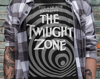 May include: A black t-shirt with a white graphic of a swirling black and white eye with the text "You are now entering... The Twilight Zone" printed on it.