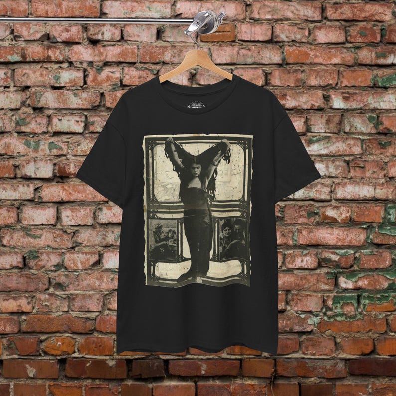 a black shirt hanging on a brick wall