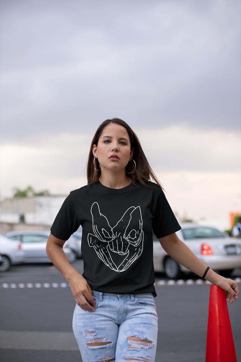 Model wearing a Labyrinth Movie T-Shirt with iconic Helping Hands design. This fantasy film tee captures the essence of the 80s cult classic, perfect for any David Bowie fan or lover of the film.