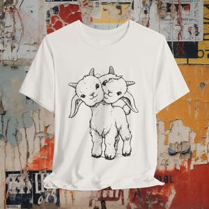 Dark punk shirt featuring a two-headed goat graphic with a vintage distressed design. Creepy occult animal tee perfect for goths, metalheads, and lovers of weird oddities. Unisex alternative gift.