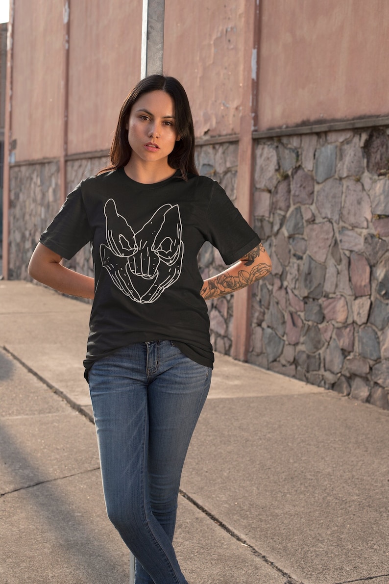 Model donning a soft, high-quality Labyrinth Movie T-Shirt featuring the famous Helping Hands. A tribute to 80s nostalgia, ideal for fans of the fantasy genre and admirers of David Bowie's Goblin King.