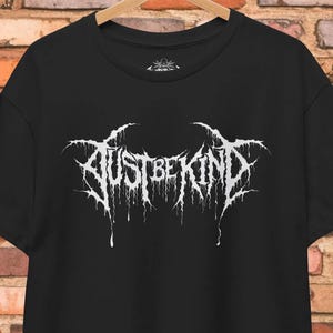 May include: Black t-shirt with a white graphic that says "Just Be Kind" in a metal band font.