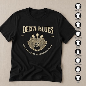 May include: A black short-sleeve t-shirt featuring a graphic with the text DELTA BLUES EST. 1928 FROM THE GREAT MISSISSIPPI DELTA. The design includes a shield shape containing three crossed acoustic guitars in a distressed beige color.