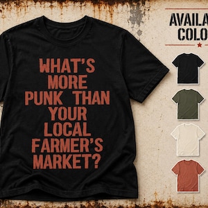 Może przedstawiać: Czarny t-shirt z krótkim rękawem z napisem WHAT'S MORE PUNK THAN YOUR LOCAL FARMER'S MARKET? nadrukowanym przetartą czerwoną czcionką. Po prawej stronie znajduje się lista dostępnych kolorów: czarny, wojskowa zieleń, naturalny i heather clay.