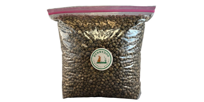 May include: A clear plastic bag filled with brown rabbit food pellets. The bag has a red zipper closure and a white label with the text "BUNNYDOO" and a cartoon rabbit.