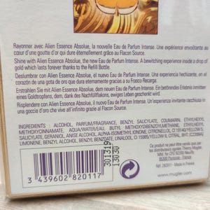 May include: Close-up of a perfume box with text in multiple languages, including English and French. The box lists ingredients and a barcode. The brand name is visible.