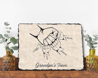 May include: Black and white illustration of four hands clasped together, with the names Olivia, James, Cara, and Hunter written below. The text "Grandpa's Team" is written below the hands.