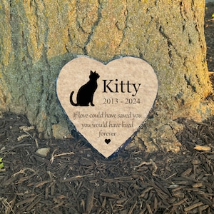 May include: Heart-shaped memorial stone featuring a black cat silhouette and the name "Kitty" with dates 2013-2024. The inscription reads, "If love could have saved you, you would have lived forever." A small heart symbol is at the bottom.
