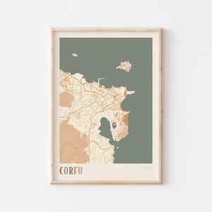 May include: A framed print featuring a map of Corfu, Greece. The map uses a muted color palette of beige, brown, and olive green. The word "CORFU" is printed in a serif font at the bottom, with "GREECE" below it.