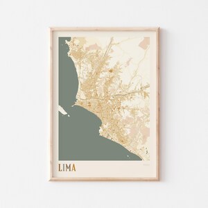 May include: A framed map print of Lima, Peru, in a neutral color palette. The map features detailed city streets and topography in shades of gold and beige, set against a muted green background. The word "LIMA" is printed in gold at the bottom.