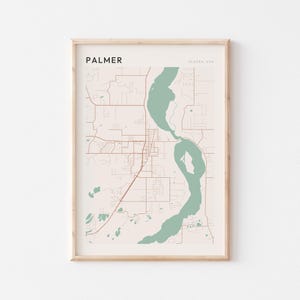 Puede incluir: Una impresión enmarcada del mapa de Palmer, Alaska, EE. UU. El mapa presenta un fondo beige claro con carreteras marrones y elementos de agua verdes. La palabra "PALMER" está impresa en negro en la parte superior izquierda.