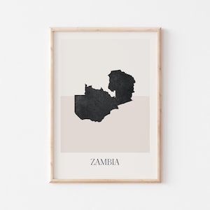 May include: Framed art print featuring a minimalist map of Zambia in black against a neutral background. The word "ZAMBIA" is printed in a simple font at the bottom. The artwork is encased in a light wood frame.