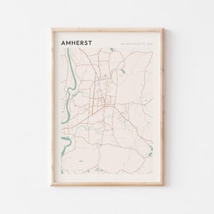 Könnte beinhalten: Gerahmter Kartendruck von Amherst, Massachusetts, USA. Die Karte zeigt ein Netzwerk von Straßen und Wasserwegen in Braun und Blaugrün auf beigem Hintergrund. Das Wort "AMHERST" ist oben in Schwarz gedruckt.