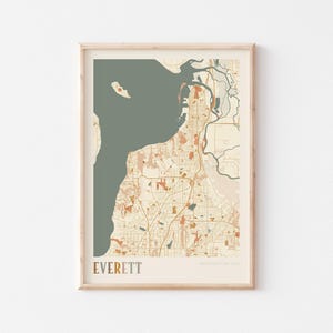 May include: Framed map print of Everett, Washington, USA. The map uses a muted colour palette with beige, orange, and green tones. The city's layout is detailed, including roads, waterways, and parks. The word "EVERETT" is printed in a bold font at the bottom.