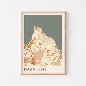 May include: A framed map print of Pacific Grove, California, USA. The map features a detailed illustration of the city's layout in shades of beige, orange, and brown against a muted green background. The words "Pacific Grove" are printed in a serif font at the bottom.