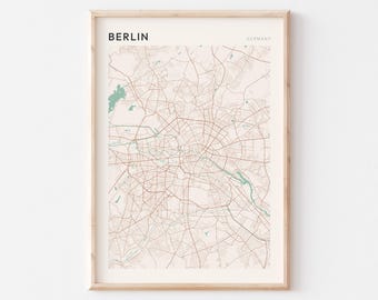 May include: A framed wall art print featuring a detailed street map of Berlin, Germany. The map displays a network of thin brown lines representing roads against a light cream background, with green areas indicating parks and water bodies.