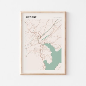 May include: Framed print of a map of Lucerne, Switzerland. The map features a beige background with brown and green details, including roads and a lake. The word "LUCERNE" is printed at the top left, with "SWITZERLAND" on the right.