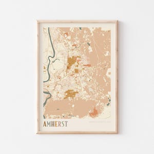 Könnte beinhalten: Ein gerahmter Kartendruck von Amherst, Massachusetts, USA, im minimalistischen Stil. Die Karte zeigt eine beige-braune Farbpalette mit einem Fluss und Straßen. Das Wort "AMHERST" ist unten aufgedruckt.